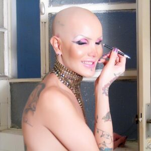 Bald transsexual pornstar Blondie Johnson masturbating long cock in bathroom