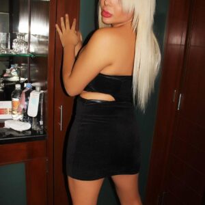 Blonde shemale model Afrika Kampos hikes up her black dress to masturbate