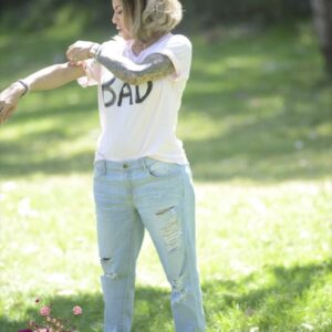 Transsexual model Foxxy poses outdoors for a SFW shoot in a T-shirt and ripped jeans