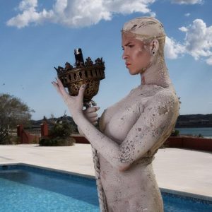 Inked fair-haired trans female Danni Daniels poses for a naked solo shoot by a pool