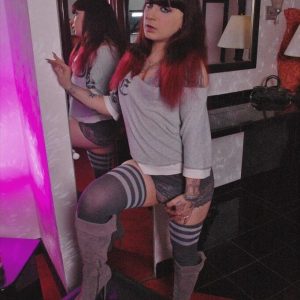 Tattooed trans girl Kelly Clare shows her big ass and hard cock in long socks