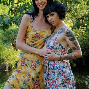 Dark-haired shemale Mandy Mitchell and a tattooed girl kiss before upskirt play