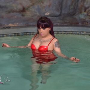Tattooed shemale Kelly Clare uncovers her big tits after getting into a hot tub